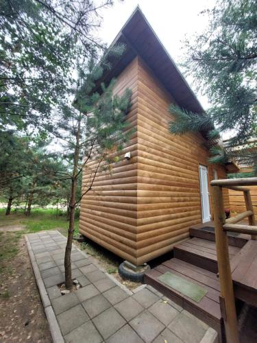 维尔纽斯Pasakų pirtelė的一座带门廊和树的小木房子