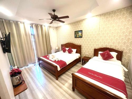 琅勃拉邦Luangprabang Villa bouathong Hotel的一间卧室配有两张床和吊扇