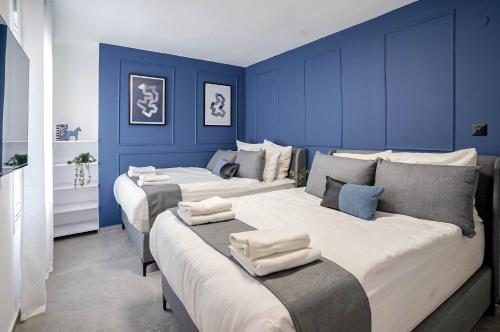 埃拉特YalaRent Mountainside Luxury apartments with Private Pool的蓝色墙壁客房的两张床