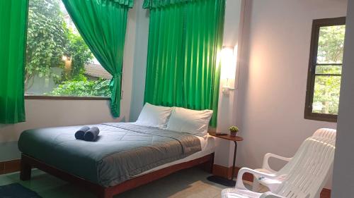 甲米镇Mountain View Hostel - Krabi的一间卧室配有一张带绿色窗帘的床和窗户。