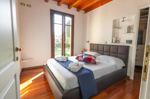 佩斯基耶拉德加达Lugana Resort & Sporting Club - Sermana Village的一间带床的卧室,位于带窗户的房间内
