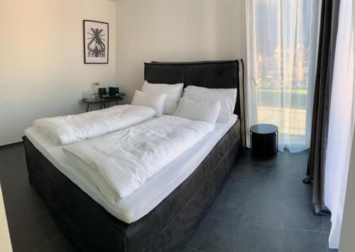 费尔德基希Motel by Maier Feldkirch - kontaktloser Check-in的卧室内的一张带白色床单和枕头的大床