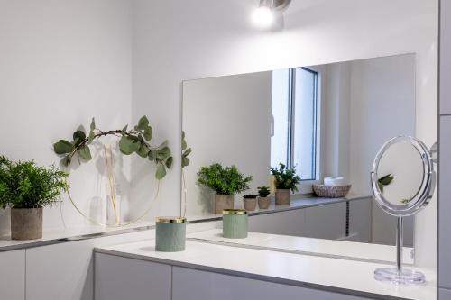 德累斯顿Sunnybelle Appartements Dresden I的白色的浴室设有镜子和盆栽植物