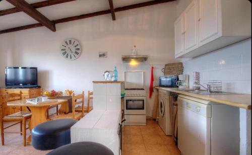 ErbajoloGîtes et Astrotourisme en Corse的厨房以及带桌子和柜台的用餐室。