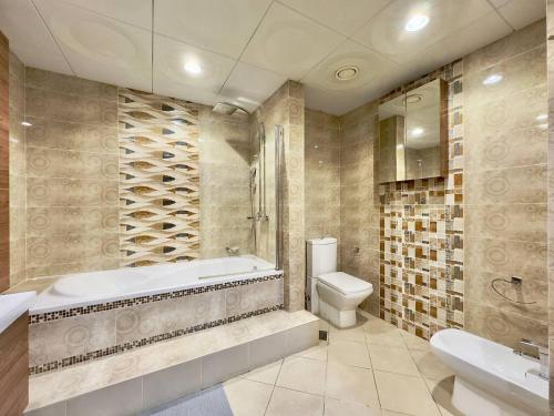 迪拜AR Holiday Home JBR 2的带浴缸、卫生间和盥洗盆的浴室