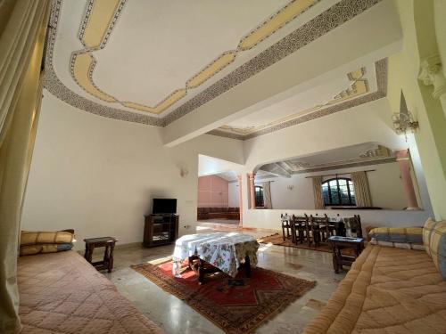 阿加迪尔Tiguimi Vacances - Oasis Villas, cadre naturel et vue montagne的一个带桌椅的大客厅
