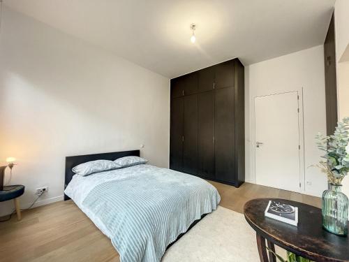 布鲁塞尔Cosy Apartment Brussels - Cinquantenaire的一间卧室配有一张大床和一张桌子