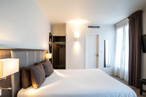 巴黎Hotel de Flore - Montmartre的卧室设有一张白色大床和一扇窗户。