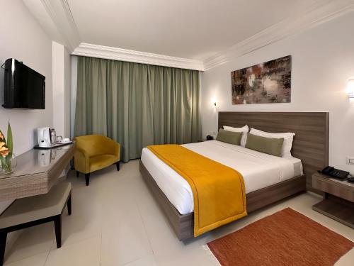 突尼斯El Oumara Hotel的配有一张床和一张书桌的酒店客房