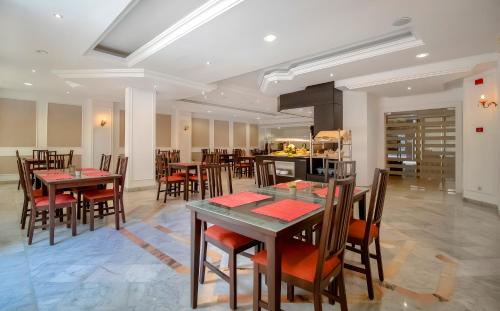 突尼斯El Oumara Hotel的一间带桌椅的用餐室和一间厨房