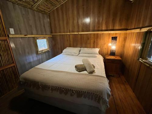 约翰内斯堡Sandton Safari Camp的木制客房内的一间卧室,配有一张床