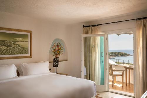 切尔沃港Romazzino, A Belmond Hotel, Costa Smeralda的一间卧室配有一张床,享有海景