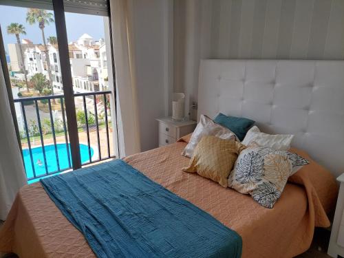 莫特里尔Chic Home Tropical beach Motril with garage的一间卧室设有一张床,享有游泳池的景色