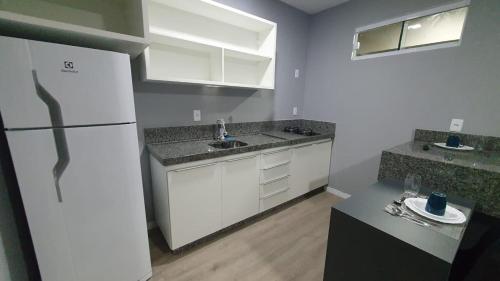 科伦巴Yes Vancouver Flats的厨房配有白色橱柜和白色冰箱。