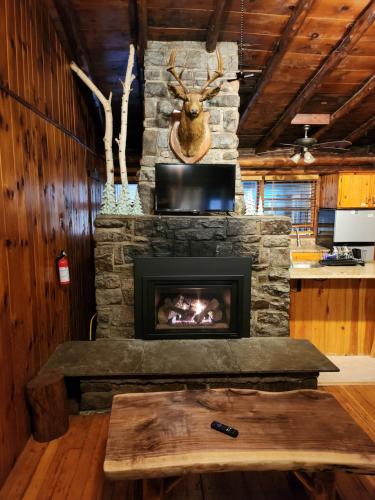 乔治湖Adirondack Diamond Point Lodge的客厅设有石制壁炉,配有桌子