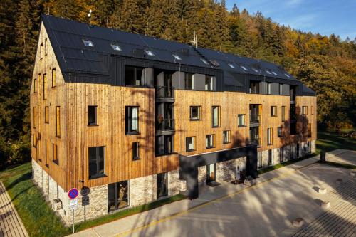 Hořejší VrchlabíApartmány Mlýn Herlíkovice的黑色屋顶的大型砖砌建筑