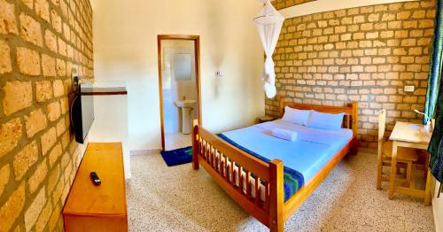 HoimaIziba lodge的一间卧室设有一张床和砖墙