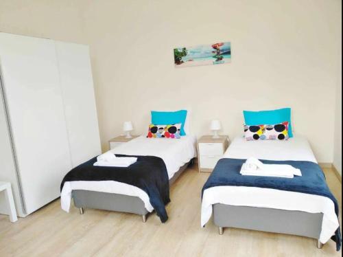 奥埃拉斯Oeiras 6的蓝色和白色的客房内的两张床