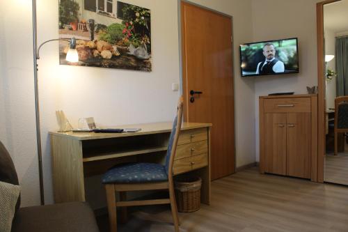 瓦伦多夫Gästehaus Niemerg的客房设有书桌和墙上的电视