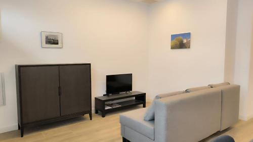 马德里Exyca Metropolitano的带沙发和电视的客厅