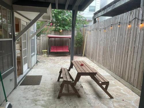 休斯顿Stylish Studio in Montrose - The Italian Plaza的庭院设有木桌和红色长凳