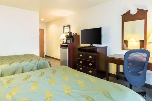 Bagua GrandeHOTEL VIP 46 SSQS的酒店客房设有一张床、一张书桌和一台电视机。