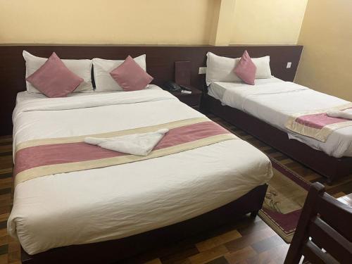 加德满都Rameshworam Hotel的两张位于酒店客房的床,配有粉红色枕头