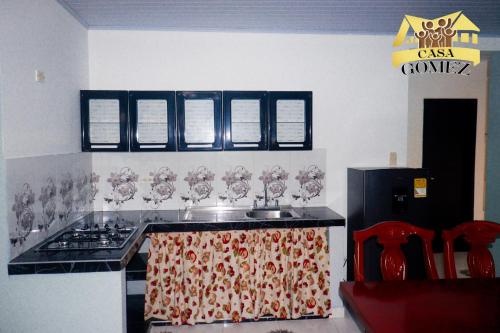 莱蒂西亚Casa Gomez Apto 2的厨房配有水槽和带酒杯的炉灶