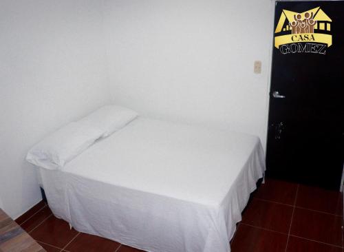 莱蒂西亚Casa Gomez Apto 2的一间小卧室,配有白色的床和黑色的门