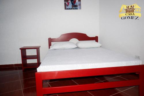 莱蒂西亚Casa Gomez Apto 2的一张位于一个红色床架和床头柜的房间的床铺