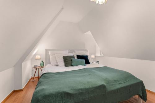 不莱梅Charmante Maisonette im Schnoor的白色卧室配有带绿色床单和枕头的床