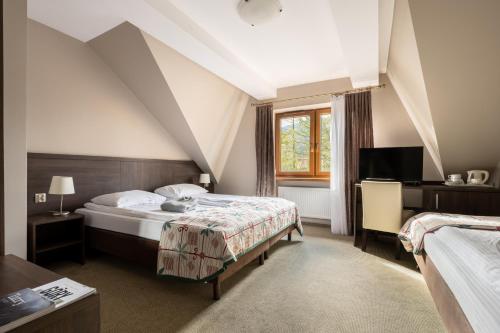 扎科帕内Dom Wczasowy Grań的酒店客房设有两张床和窗户。