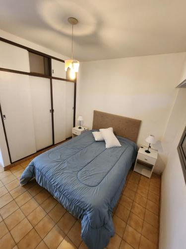 马德普拉塔Departamento Centro de la Ciudad的一间卧室配有蓝色的床和2个床头柜