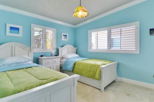 伊斯拉莫拉达West Plaza Del Lago的一间蓝色卧室,配有两张床和吊灯