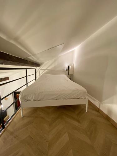 巴黎美迪亚酒店的铺有木地板的客房内的一张白色床