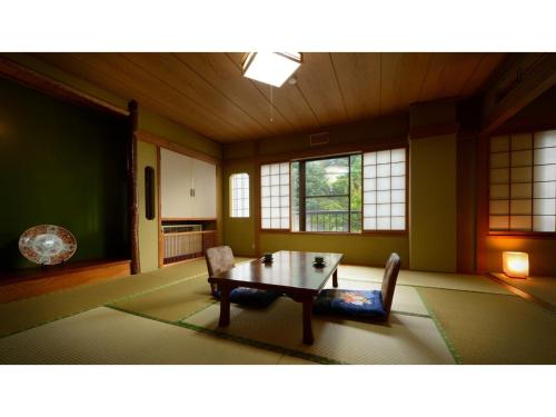 福岛Hotel Tenryukaku - Vacation STAY 16415v的客厅配有桌椅和窗户。