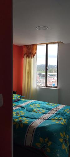 伊皮亚莱斯Ipiales puerta de oro的一间卧室设有一张床和一个窗口
