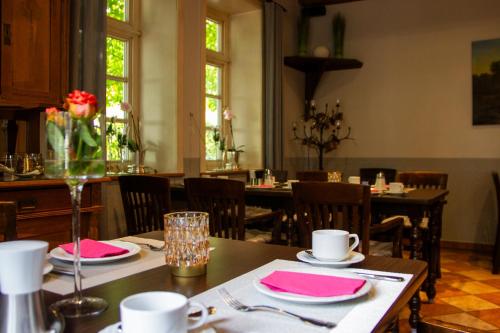 LastrupLandhaus Lastrup的用餐室配有桌椅和粉红色餐巾