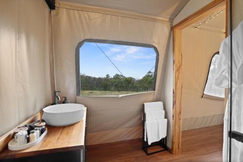 ExcelsiorAkuna Estate - Luxury Glamping Experience的帐篷内的浴室设有水槽和窗户
