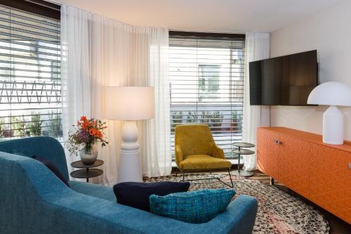 布鲁尼科ANTON Dolomites Hideaway的客厅配有蓝色的沙发和椅子