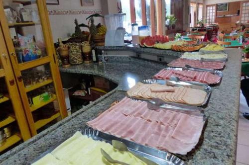 坎波斯杜若尔当Pousada Alpes da Serra Campos do Jordão的上面有许多盘子的食物的柜台