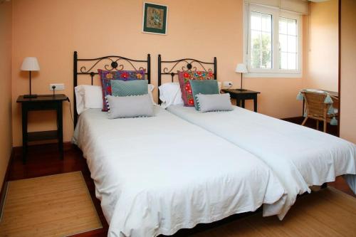佩罗拉Finca Tras de Casa的卧室配有带枕头的大型白色床