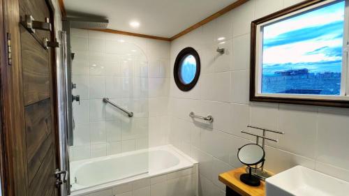 科伊艾科Cabaña - Granja Lago Frío的带浴缸、水槽和镜子的浴室