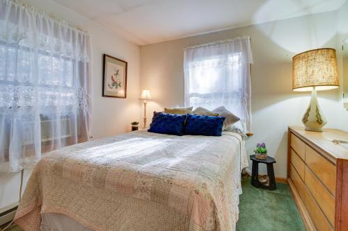 TiconderogaHague Vacation Rental about 2 Mi to Lake George!的一间卧室配有一张带蓝色枕头的床和一扇窗户。