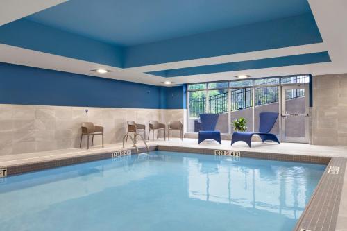 米德兰Hampton Inn Midland, On的一座拥有蓝色墙壁和椅子的酒店游泳池