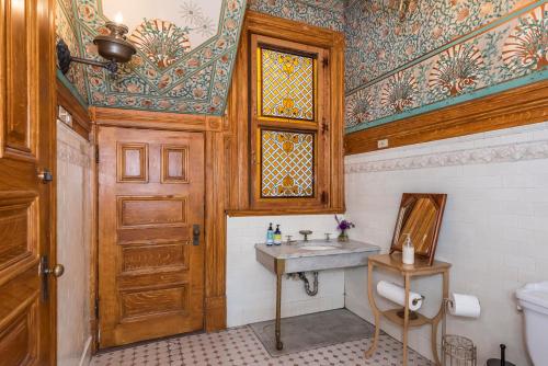 旧金山Chateau Tivoli Bed and Breakfast的一间带水槽和木门的浴室