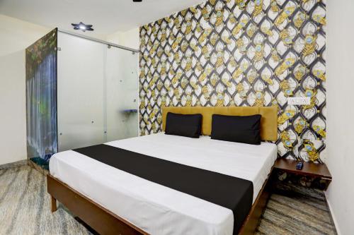 加济阿巴德OYO Flagship Hotel Blue Diamond的一间卧室设有一张床和一面墙