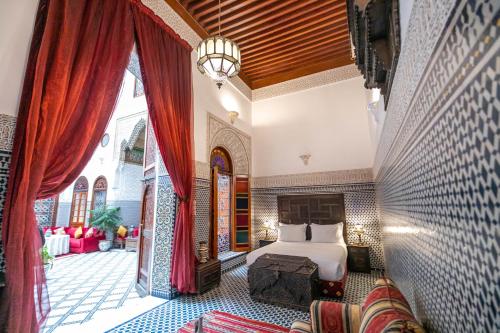 非斯麦地那佩林庭院旅馆的一间卧室设有一张床和一个大窗户