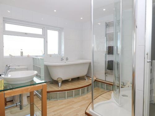 普尔赫利The Beach House的白色的浴室设有浴缸和水槽。