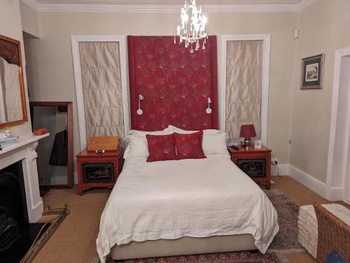 开普敦La Montagne Observatory的一间卧室配有一张大床和红色床头板